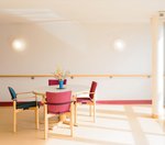 Ein mit Blumen dekorierter Tisch mit vier Stühlen im Inneren des Hauses Tannenhof.