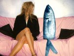 Eine Frau sitzt auf dem Sofa neben einem Fisch