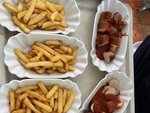 Pommes und Currywurst in Schälchen