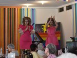 Zwei Drag Queens in pinken Kleidern klatschen