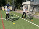 Zwei junge Frauen machen ein Wettrennen mit Rollator und Brillen