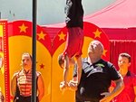 Ein junge macht einen Handstand auf der Hand von einem älteren Mann