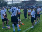 Mitarbeitende in Fußball-Trikots auf einem Fußballplatz