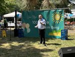 Herr Bischoff hält eine Rede vor dem Jubiläumsbanner im Garten.