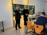 Zwei Personen vor der weihnachtlich dekorierten Schultafel im Klassenzimmer